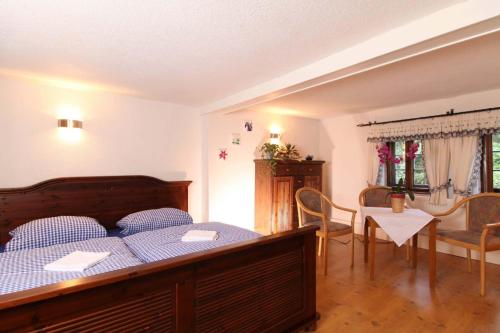 a bedroom with a bed and a table and chairs at Gaststätte & Pension Lochbauer in Plauen