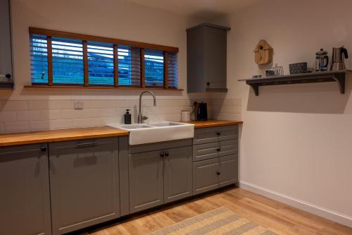 a kitchen with a sink and a window at The Wolfie Lodge in Carbost
