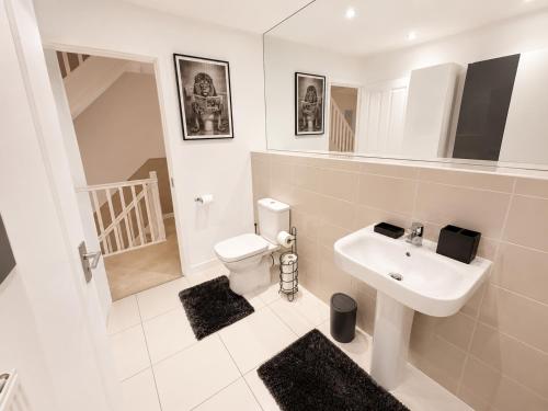 a white bathroom with a sink and a toilet at MpaNjus - Double Rooms, Shared House in Bristol
