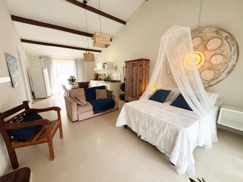 a bedroom with a bed with a mosquito net at Loft Caeté in Araruama