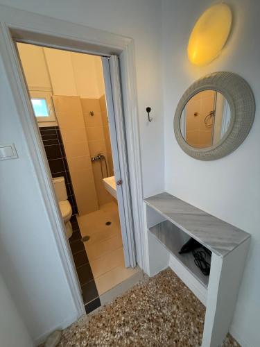 a bathroom with a mirror and a walk in shower at Windmill Rooms in Antiparos