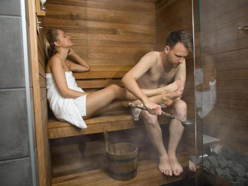 a man and woman sitting in a sauna at ibis Tallinn Center in Tallinn