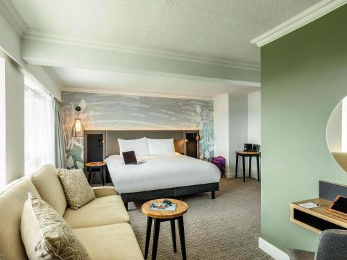 a hotel room with a bed and a couch at Mercure Bedford Centre Hotel in Bedford