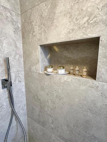 a shower with four candles on a shelf in a bathroom at APP Steps to the Sea 2026 in Funtana
