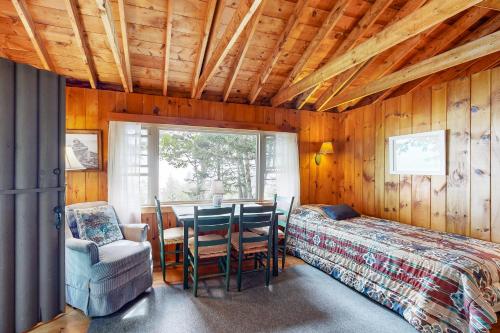 a bedroom with a bed and a table and chairs at Water Views & Deck! Peaceful Northport Escape in Northport