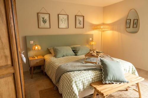 a bedroom with a bed and a table and mirrors at Le Castelas - Hébergement complet in Aurons