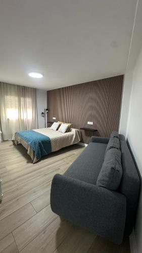 a bedroom with a bed and a couch at Hostal Casa Amalia in Teruel
