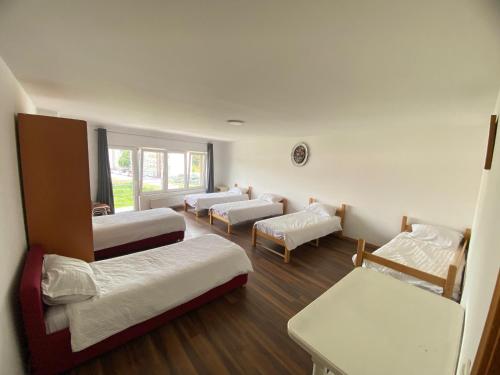 a room with four beds and a couch at Otoka Hostel in Sarajevo
