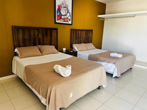 a room with two beds with towels on them at Hotel D’Cural in Oxkutzcab