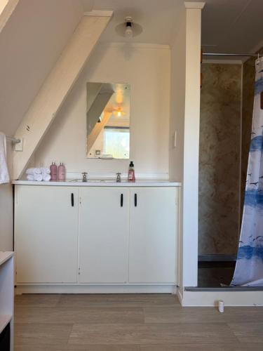 a white bathroom with a sink and a mirror at Awhina's Lodge in Ohakune