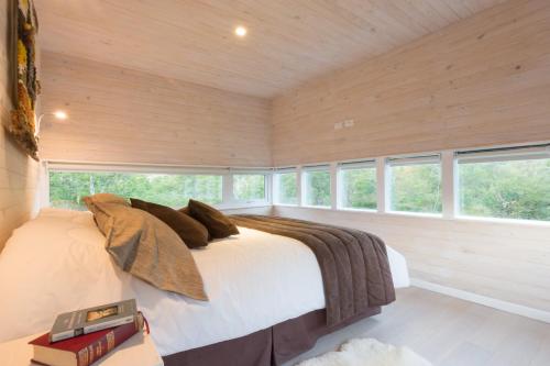 a bedroom with a bed in a room with windows at Endemiko in Malalcahuello
