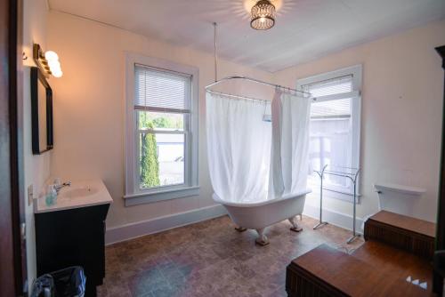 a bathroom with a tub and a sink and a window at Old Clark Inn in Marlinton