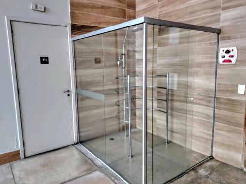 a glass shower in a room with a door at The Cittyplex Home Osasco Estilo & Conforto in Osasco