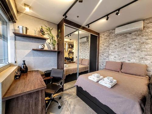 a bedroom with a bed and a desk and a table at The Cittyplex Home Osasco Estilo & Conforto in Osasco