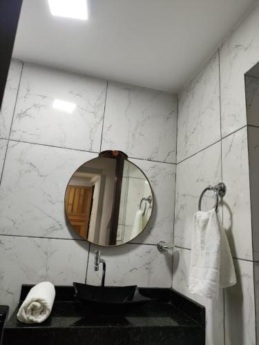 a bathroom with a black sink and a mirror at Recanto dos sabias AP01 in Conservatória