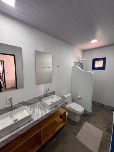 a bathroom with two sinks and a toilet at Califeira do Patacho in Pôrto de Pedras