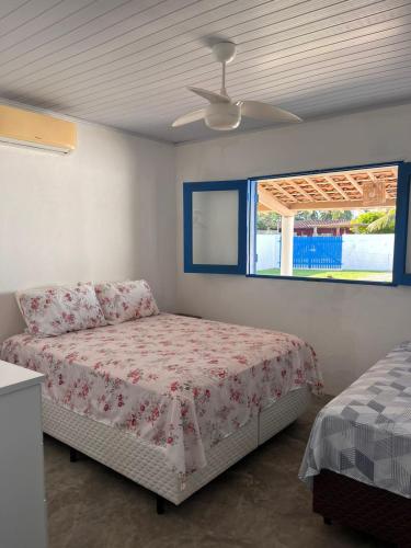 a bedroom with a bed and a window at Califeira do Patacho in Pôrto de Pedras