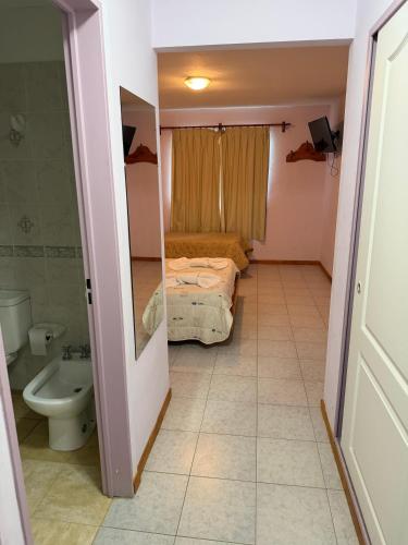 a small bathroom with a bed and a toilet at Hotel Hielo Azul 1 in El Bolsón