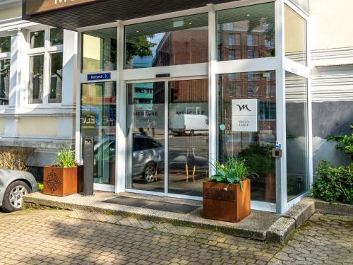 a building with glass doors with a car in it at Mercure Hotel Luebeck City Center in Lübeck