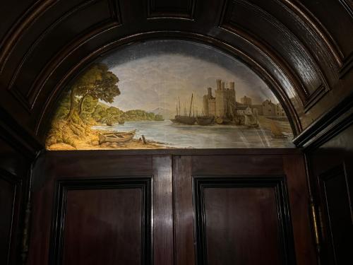 a painting of a river with a ship at Plas Glynllifon Mansion in Caernarfon