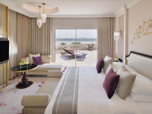 a hotel room with a large bed and a living room at Mövenpick Hotel Bahrain in Manama