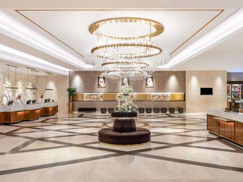 a lobby with a large chandelier and a fountain at Movenpick Hotel & Residences Hajar Tower Makkah in Mecca