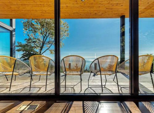 a group of chairs sitting on top of a porch at Secret Charlevoix - River View & Spa in Les Éboulements
