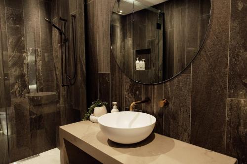 a bathroom with a sink and a large mirror at Kais Retreat in Punakaiki