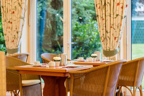a dining room with tables and chairs and a window at Montana Hotel Mönchengladbach in Mönchengladbach