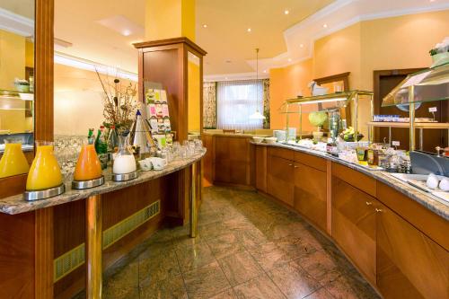 a large kitchen with a long counter in a restaurant at Montana Hotel Mönchengladbach in Mönchengladbach