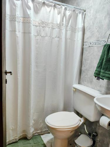 a bathroom with a toilet and a shower curtain at Kaike in Caleta Olivia