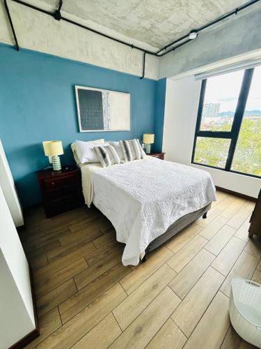 a bedroom with a bed and a blue wall at Cozy Apartment 4 degrees north in Las Victorias