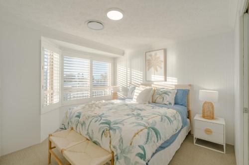 a white bedroom with a bed and a window at Seacrest 9 in Gold Coast