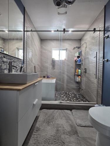 a bathroom with a shower with a sink and a toilet at Room with Shared Bathroom - Stampede & Mountains in Calgary