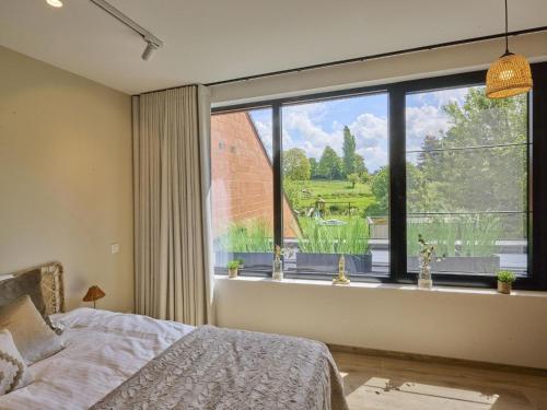 a bedroom with a bed and a large window at t Margrietje in Riemst
