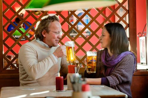 a man and a woman sitting at a table drinking beer at Braugasthof Trompete in Eichstätt