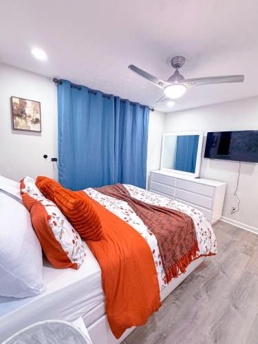 a bedroom with a bed with an orange blanket at Comfort Cove Snellville in Snellville