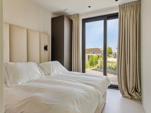 a bedroom with a large bed and a large window at Zilte Watervilla in Kamperland