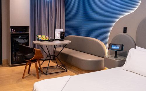 a bedroom with a bed and a table and chairs at Motel das Nações in Bauru