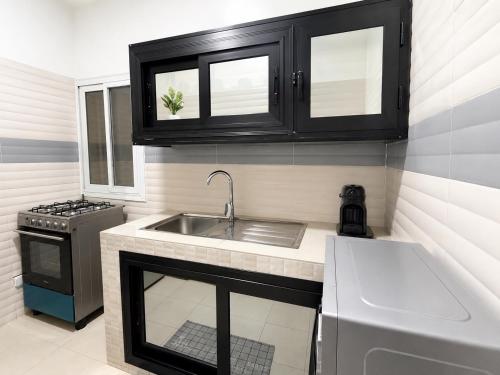 a small kitchen with a sink and a stove at Modern Central Studio - Dakar Plateau in Dakar