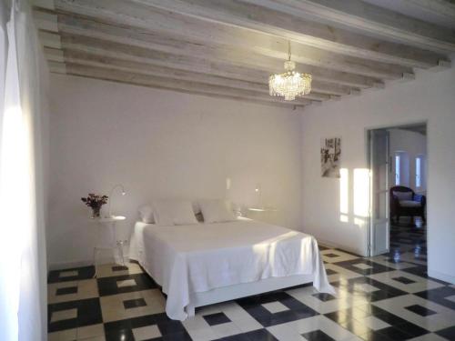 1 dormitorio blanco con 1 cama y suelo a cuadros en La Nube de San Miguel, en Cádiz