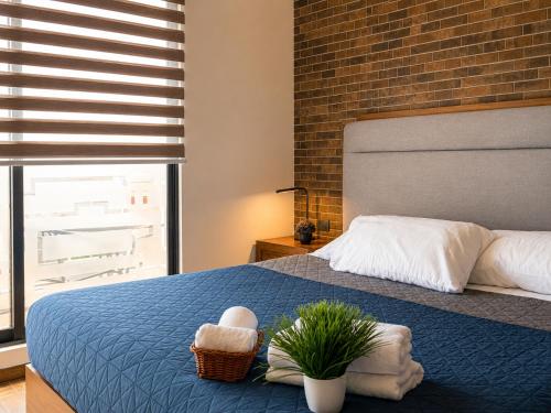 a bedroom with a blue bed with a brick wall at DG Comfort - Depart Privado con balcon in Villahermosa