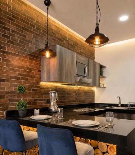 a kitchen with a brick wall and a table with chairs at DG Comfort - Depart Privado con balcon in Villahermosa