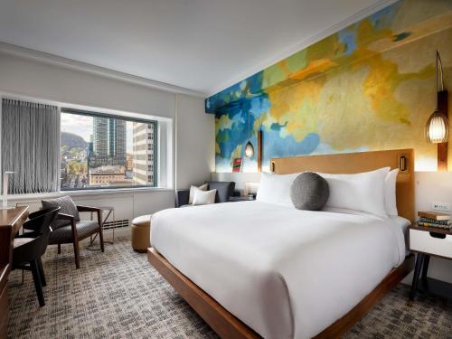 a hotel room with a large bed and a desk at Fairmont The Queen Elizabeth in Montreal