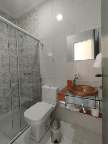a bathroom with a toilet and a shower and a sink at Pousada Posto Junior - Madalena CE in Madalena