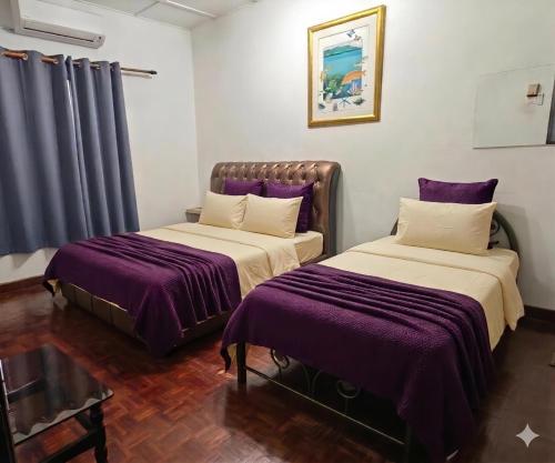 two beds in a room with purple sheets at Homestay Shah Alam OneB, 2-12 pax, I-city & UiTM in Shah Alam