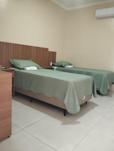 two beds sitting next to each other in a room at Pousada Posto Junior - Madalena CE in Madalena