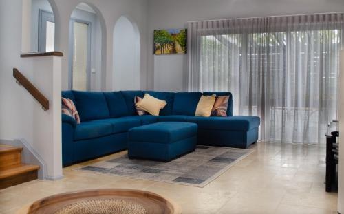a blue couch sitting in a living room at Koblenz Haus - “Heart of the Barossa” - (New Mgmt) in Tanunda