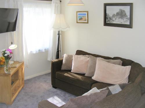 a living room with a couch and a television at Chynoweth in Saint Merryn
