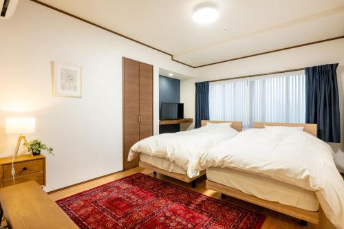 a bedroom with two beds and a window at あわら湯のまち駅から徒歩3分の湯の花ハウス in Awara